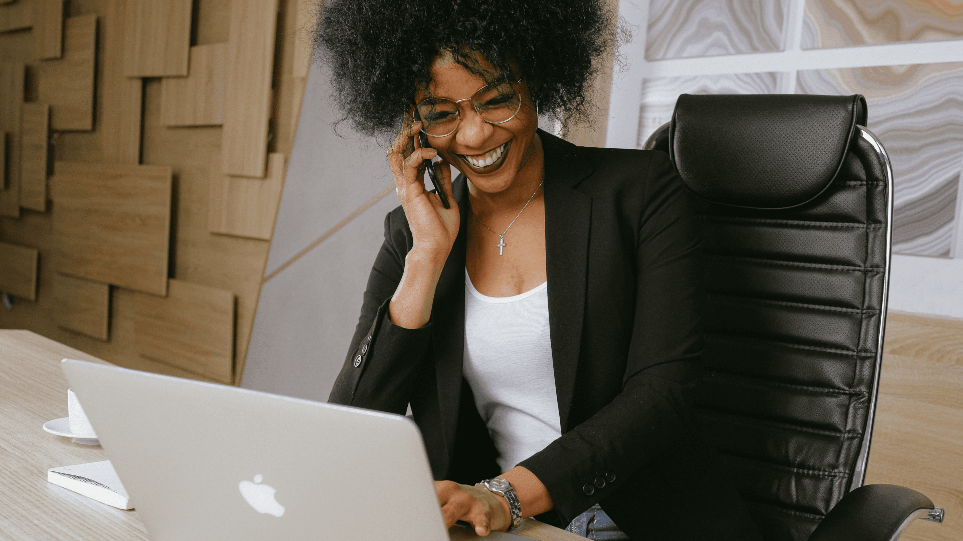 Woman on the phone with her laptop sitting and laughing