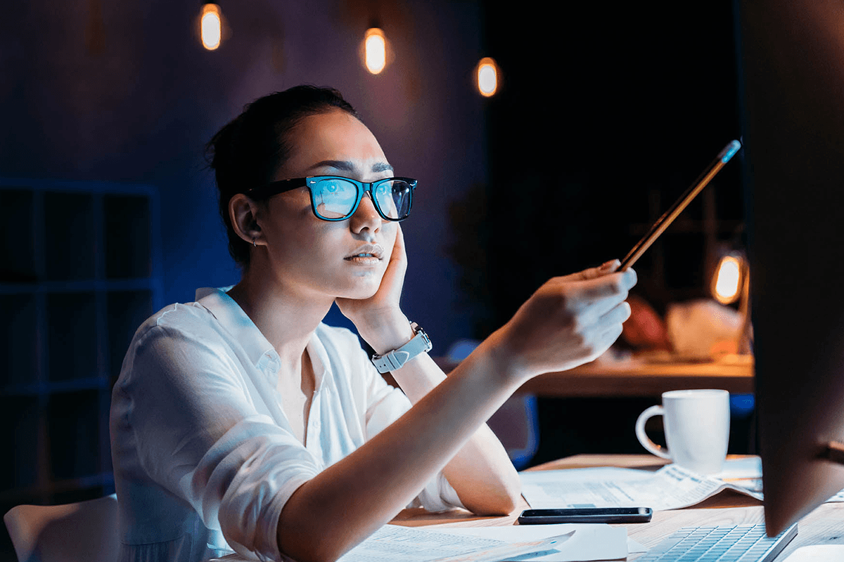Woman with glasses holding a pen