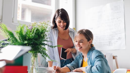 Två leende kvinnor på kontor