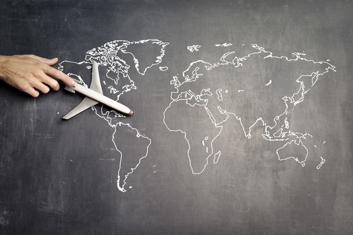Leksaksflygplan på en svart tavla som föreställer en världskarta